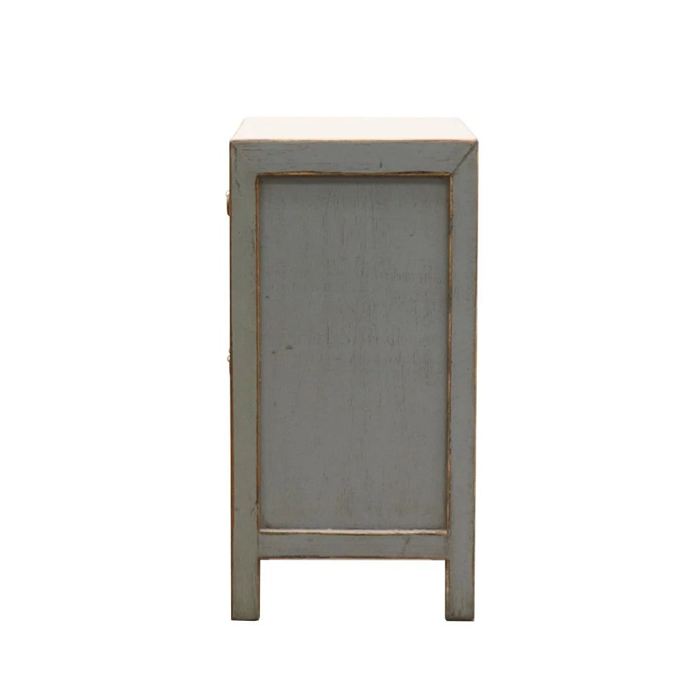 Side profile of small bedside cabinet with a distressed light grey painted finish, shown against a plain white background