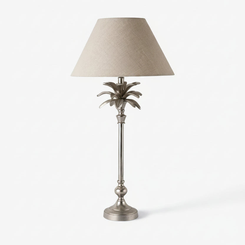 Decorative table lamp with a palm leaf design on a white background