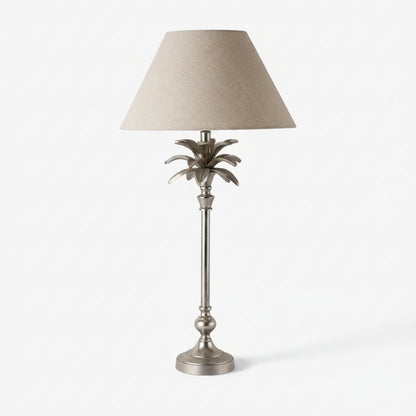 Decorative table lamp with a palm leaf design on a white background