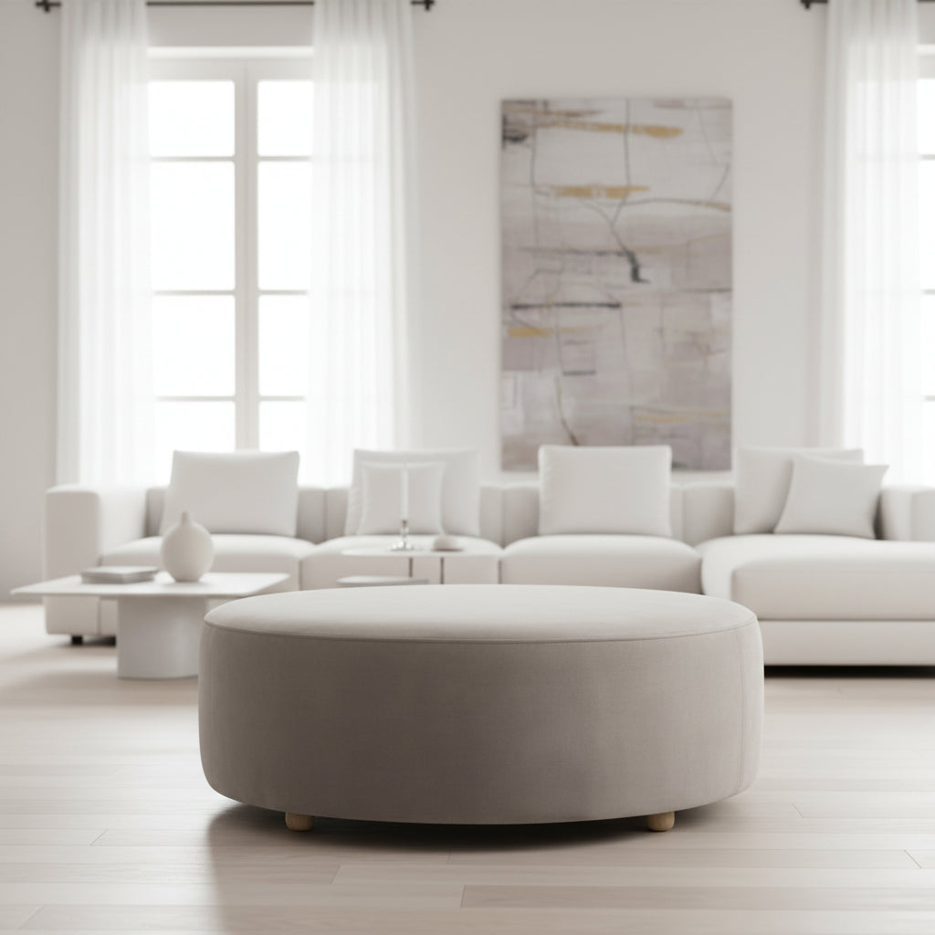 Mouse Grey Round Ottoman sitting in front of a modern modular white sofa 