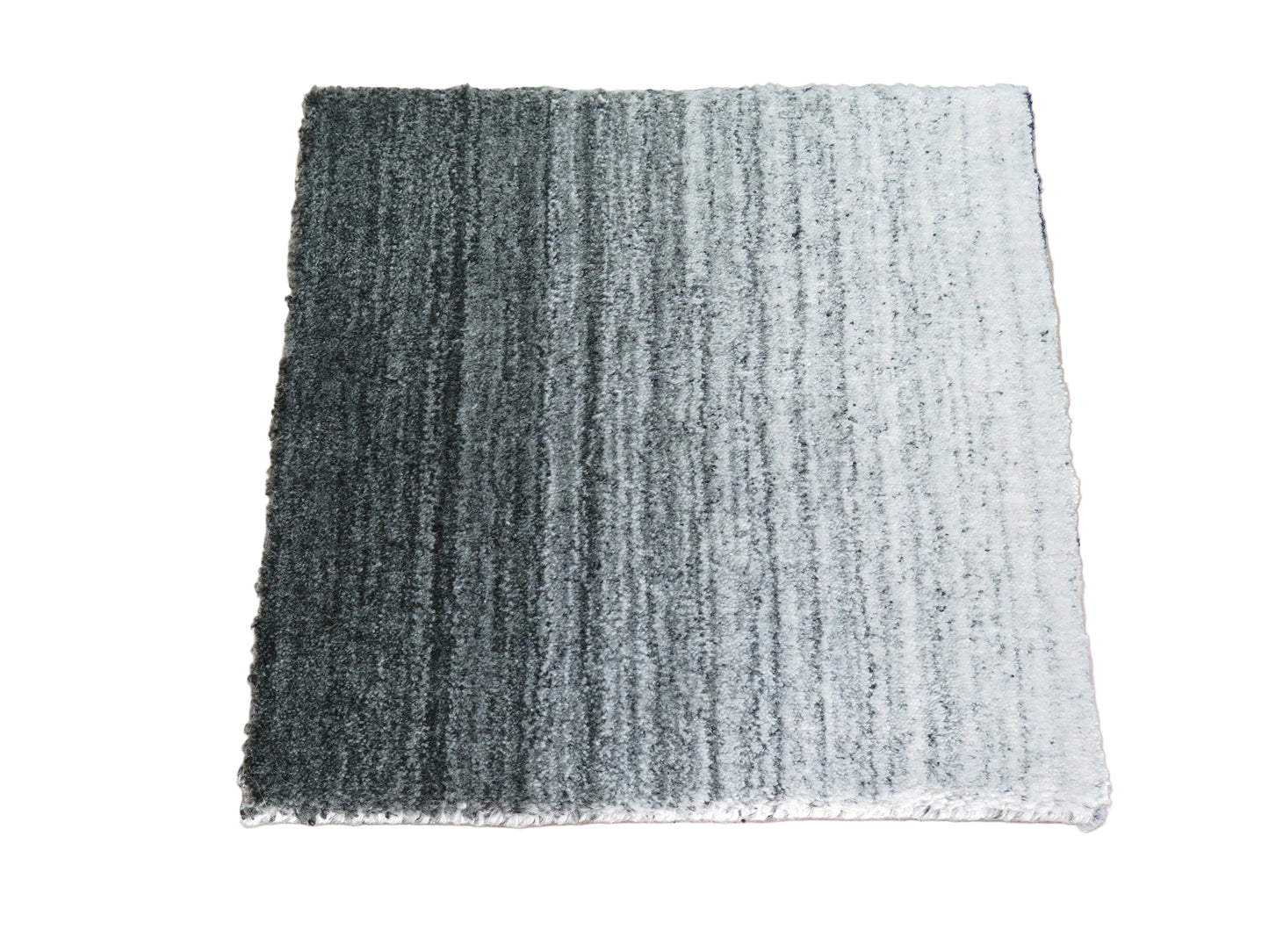 Textured grey and white rug sample on a white background