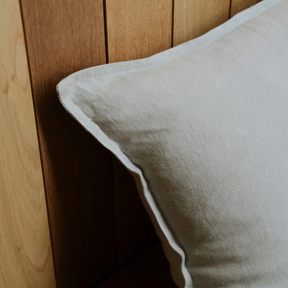 Grey pillow against a wooden headboard