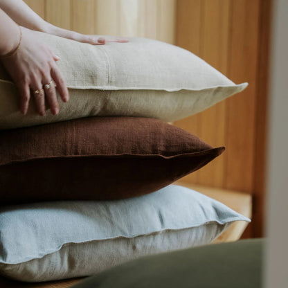 Stack of colorful pillows on a wooden surface with a blurred background