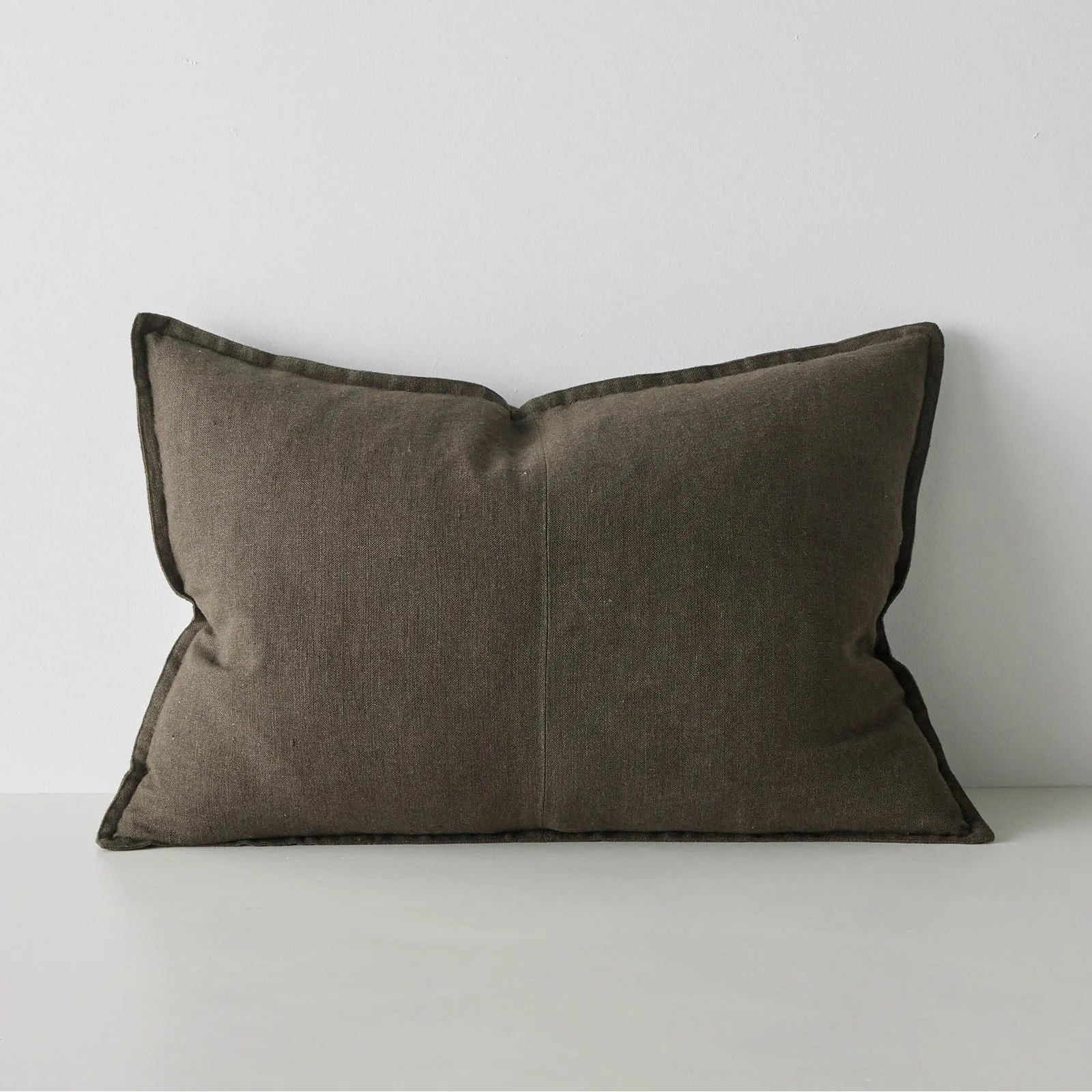 Brown pillow on a white surface with a light gray background