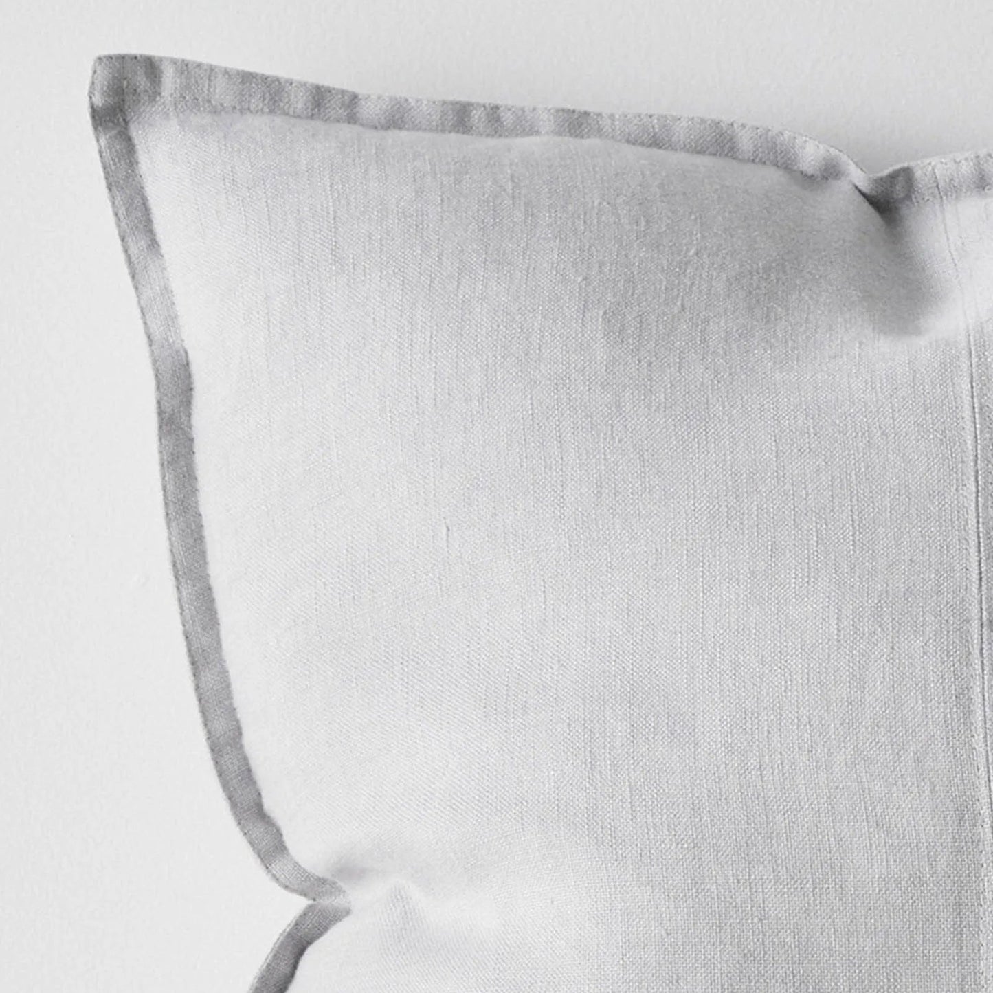 Light grey cushion with a subtle pattern on a light grey background