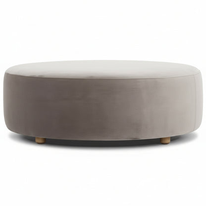Round ottoman in mouse grey velvet with light wooden legs.